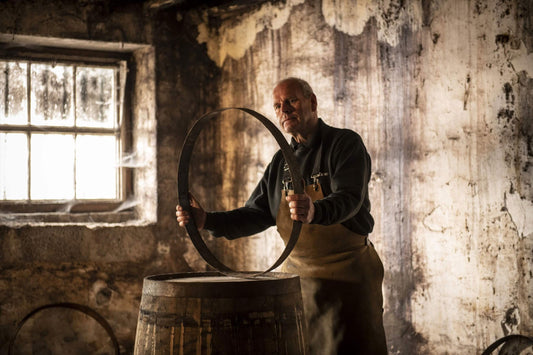 Barrel maker inspecting a ring for the barrel.