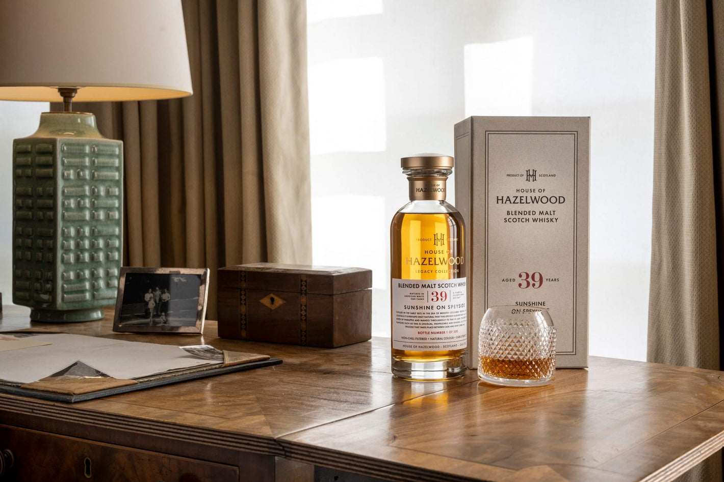 A bottle of Sunshine on Speyside next to its box, sitting on a desk.